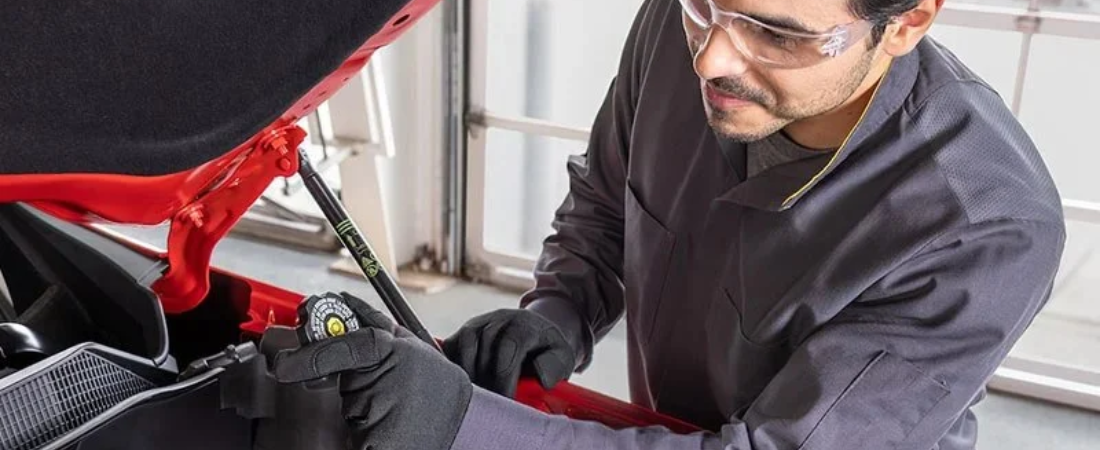 Certified Chevrolet Service technician working under the hood at Atzenhoffer Chevrolet in Victoria, Texas
